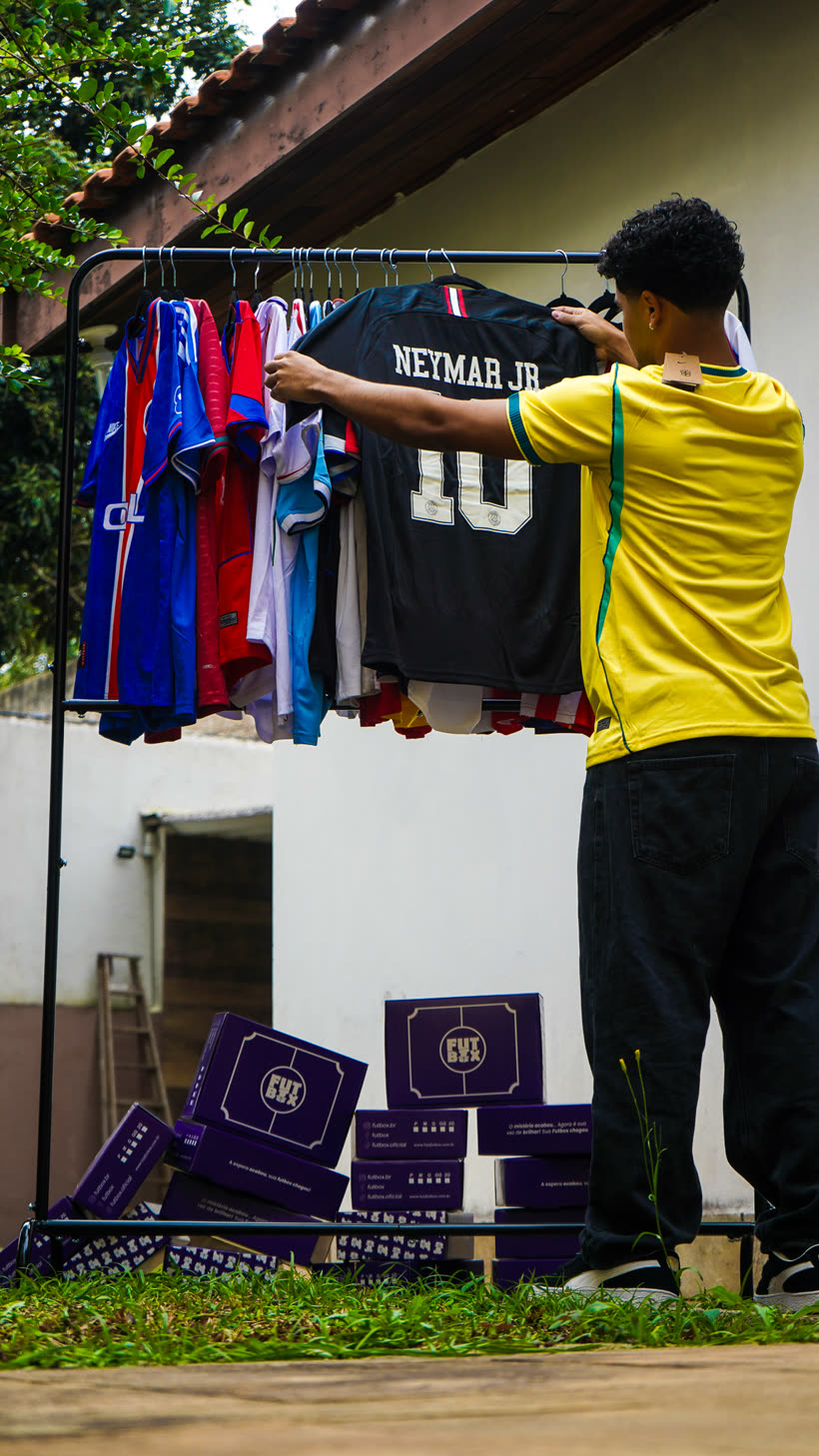 Curadoria escolhendo camisa na arara